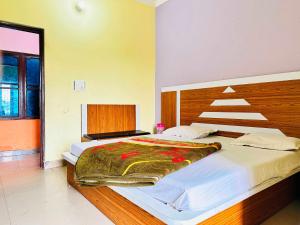 a bedroom with a large bed with a wooden headboard at OYO Hotel Verma Residency in Katra