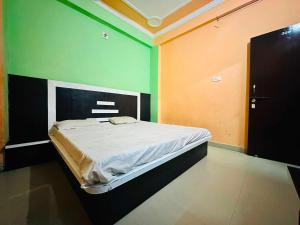 a bed in a room with green and orange walls at OYO Hotel Verma Residency in Katra