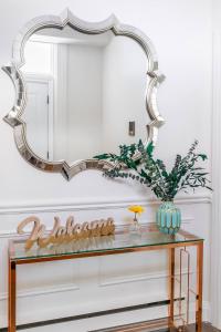 a mirror on a wall above a console table at Sweet Home in Toronto