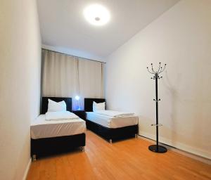 Zimmer mit 2 Betten und einer Lampe in der Unterkunft Apartment Hotel Adler Leipzig in Leipzig