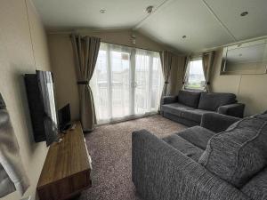a living room with a couch and a tv at Superb 8 Berth Caravan For Hire At A Great Holiday Park In Norfolk Ref 50007a in Great Yarmouth