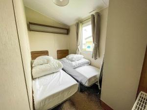 two beds in a small room with a window at Superb 8 Berth Caravan For Hire At A Great Holiday Park In Norfolk Ref 50007a in Great Yarmouth