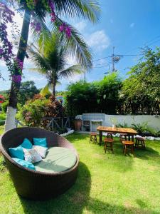 a garden with a table and a chair and a bench at Estrela Praia in Fernando de Noronha