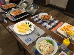 una mesa de madera con platos de comida. en Mizuho Inn Iwami Masuda - Vacation STAY 17367v en Masuda