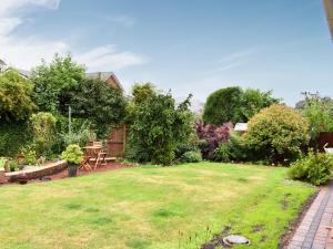 un jardín con césped, mesa y sillas en Meadowfield View, en Ryton