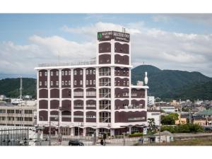 ein großes weißes Gebäude mit einem Uhrturm in der Unterkunft Mizuho Inn Iwami Masuda - Vacation STAY 17367v in Masuda