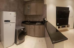 a kitchen with a white refrigerator and a dishwasher at شقة فندقية فاخرة in Taif +7 photos