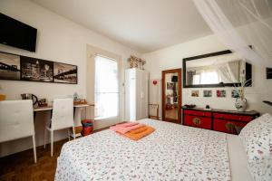 1 dormitorio con cama, escritorio y espejo en B&B Sweet Dreams, en Asolo