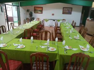uma sala com mesas longas com toalhas de mesa verdes em hotel american em Ovalle