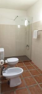 een badkamer met 2 toiletten en een douche bij Casas da Barra in Praia de Mira
