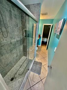 y baño con ducha y puerta de cristal. en Relaxing 1bed 1bath Villa In Downtown Red Hook! en Nazareth