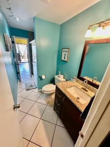 a bathroom with a sink and a toilet and a mirror at Relaxing 1bed 1bath Villa In Downtown Red Hook! in St Thomas