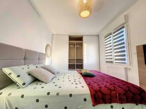 - une chambre avec un grand lit blanc et une couverture rouge dans l'établissement Appartement central avec très jolie vue, à Ajaccio