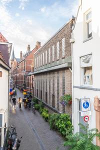 a city street with buildings and people walking down the street at Hostel het Archief in Zwolle