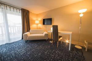 TV a/nebo společenská místnost v ubytování Hôtel Le Dormeur