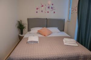 a bed with two folded towels on top of it at Urban Oasis, Stylish Short Stay Apartment in Piraeus Center in Piraeus