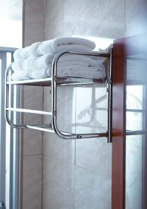 una pila de toallas en un toallero en el baño en Hotel Lottus, en Quito