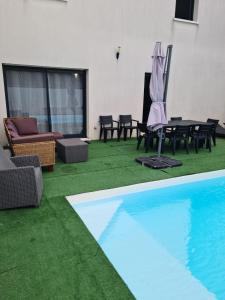 een kamer met een zwembad, stoelen en een tafel bij Cherad in Arveyres