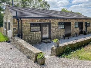 a small stone building with a door and windows at Serenity- Uk38551 in Endon