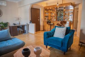 un salon avec un canapé bleu et une table dans l'établissement Urban Oasis, Stylish Short Stay Apartment in Piraeus Center, au Pirée
