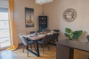 une salle à manger avec une table et une horloge au mur dans l'établissement Urban Oasis, Stylish Short Stay Apartment in Piraeus Center, au Pirée 11 autres photos