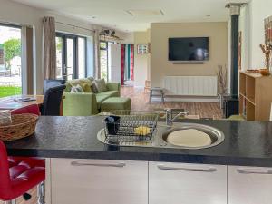 a kitchen with a sink and a living room at Townsend Pod in Greinton