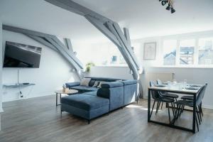 ein Wohnzimmer mit einem blauen Sofa und einem Tisch in der Unterkunft Appartement Condé hyper centre-ville in Charleville-Mézières