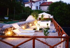a patio with white lounge chairs and lights at FOUR WHITE APARTMENTS in Agerola