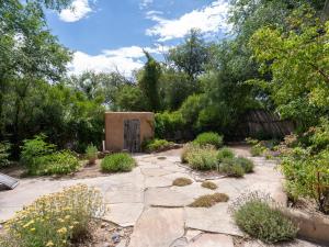 un jardín con una pasarela de piedra y una puerta en El Nido Lane Tesuque, 1 Bedroom, Sleeps 2, Private Yard, WiFi, Washer/Dryer en Santa Fe