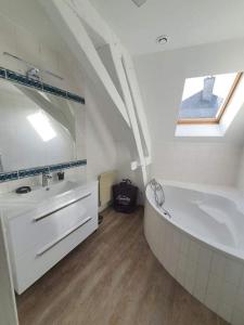 ein weißes Badezimmer mit Badewanne und Waschbecken in der Unterkunft Appartement Condé hyper centre-ville in Charleville-Mézières + 20 Fotos