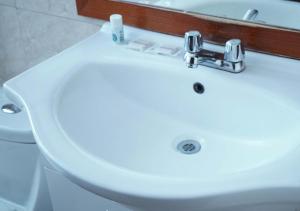 a bathroom with a white sink and a toilet at Hotel Lottus in Quito