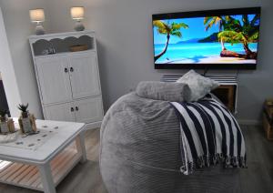 a bedroom with a bed and a flat screen tv at 201 Hexrivier in Hartenbos