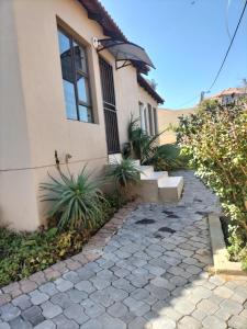 a house with a stone walkway in front of it at AKANI Guesthouse Cosmo city in Roodepoort