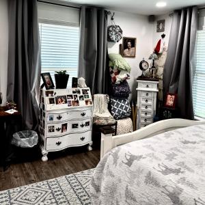 a bedroom with a bed and a dresser with pictures at Pet Friendly Graham 2 Bedroom Home Christmas 365 at The Mistletoe Farm in Graham