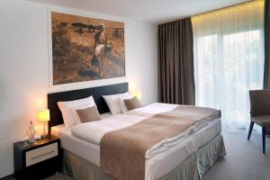 Hotel Mousson في ميشالوفيتسي: غرفة نوم بسرير كبير عليها لوحة على الحائط