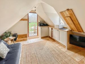 a living room with a couch and a kitchen at Hazel Nook in Trotton