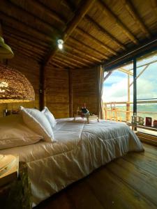 a large bed in a room with a large window at Hakuna Matata Glamping timon in Salento