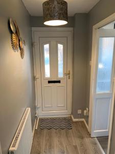 a hallway with a white door and a window at Stylish, cosy, home with off-road parking 