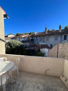 a balcony with a table and chairs and buildings at Charmant séjour Marseillais in Marseille