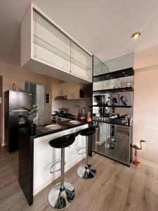 a kitchen with a bar with stools and a refrigerator at Apartment with 2 bedrooms next to Miraflores in Lima
