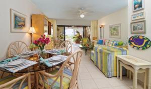 uma sala de estar com uma mesa e um sofá em Beach Living at Villas Pappagallo Beachfront 22 em West Bay