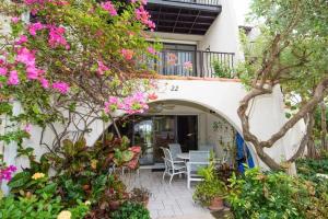 a patio with flowers and a table and chairs at Beach Living at Villas Pappagallo Beachfront 22 in West Bay