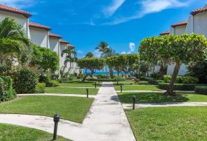 a walkway through a park with trees and grass at Beach Living at Villas Pappagallo Beachfront 22 in West Bay