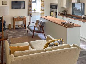 uma sala de estar com um sofá e uma cozinha em The Stable em Bridgwater