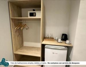 a small kitchen with a refrigerator and a microwave at Z Hotel Boutique in Puerto Iguazú