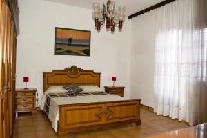 - une chambre avec un lit en bois et un lustre dans l'établissement Is Cogas, à Masainas
