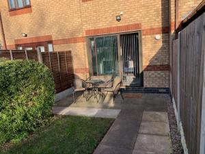 a patio with chairs and a table in front of a building at Stylish, cosy, home with off-road parking 