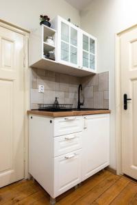 una cocina con armarios blancos y fregadero en ApartPro Apartments, Veliko Tarnovo, en Veliko Tŭrnovo