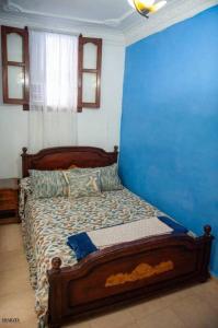 Chez laasri في شفشاون: غرفة نوم بسرير مع جدار ازرق
