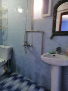 Chez laasri في شفشاون: حمام مع حوض ومرحاض ومرآة